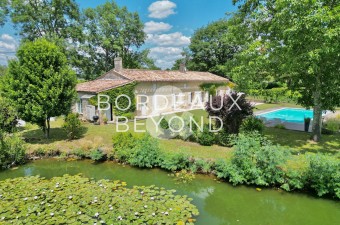 À seulement 10 minutes de Saint-Émilion, cette superbe maison en pierre de plain-pied entièrement rénovée vous offre un cadre paisible entouré de vignes et d'un étang.